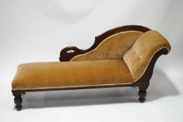 A Victorian mahogany chaise longue with carved detail to the frame, on turned legs,