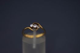 A three stone diamond ring, stamped '18ct', the graduated brilliant and single cuts on a twist,