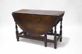 A 19th century oak gateleg table with drawer to one end, on turned and block legs,