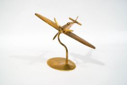 A brass model of a Spitfire with revolving propeller, on stand,