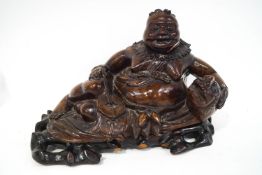 A Chinese carved hardwood figure of a seated God, 29cm wide,