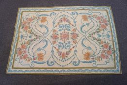 A 20th century French needlework rug with garlands of flowers and Classical scroll decoration,