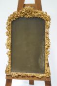 An 18th century style wall mirror in carved gilt wood frame with flower heads,