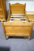 A child's pine sleigh bed, 109cm wide x 204cm long,