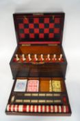 A Victorian rosewood games compendium with ivory chess and draughts sets, cribbage board,