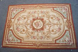 A modern Aubusson style rug, woven in shades of beige, pink and green,