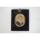 An early 19th century portrait miniature of a young boy wearing a blue jacket, Watercolour on card,