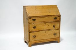 A 19th century stripped pine bureau with fall front above three graduated long drawers on bracket