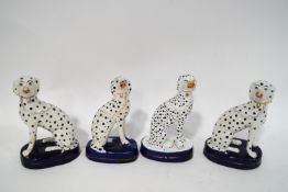 A pair of 19th century Staffordshire figures of seated Dalmatians, 13cm high,