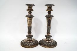 A pair of Sheffield plate candlesticks, with foliate scroll relief decoration,