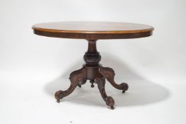 A Victorian oval walnut loo table on heavily carved column and quadruple legs,