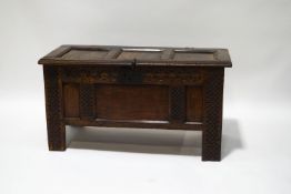 A late 17th century carved oak coffer with panelled sides and lid, iron lock and butterfly hinges,