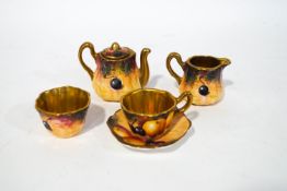 An early 20th century miniature tea set in the Worcester style, hand painted with fruit,