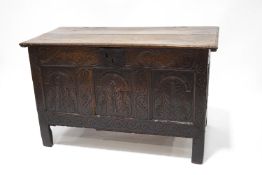 A 17th century and later oak coffer with heavily carved front panel and legs,