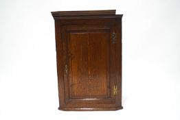 A small 18th century oak hanging corner cupboard,