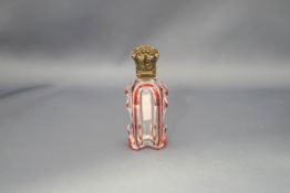 A red flash glass scent bottle, with an unmarked gilded embossed hinged cover, with stopper, 9.