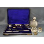 A cased silver mounted ladies manicure set; a silver mounted glass scent bottle;