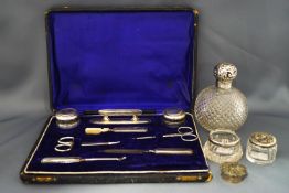 A cased silver mounted ladies manicure set; a silver mounted glass scent bottle;
