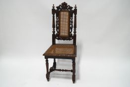 A Victorian carved oak hall chair with cane seat and back, on turned legs and supports,