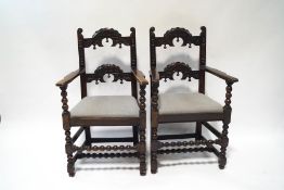 A pair of 19th century oak armchairs in the Derbyshire style, with carved back and crest rails,