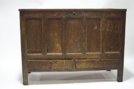 An early 18th century oak mule chest, panelled lid and sides with two drawers to base,