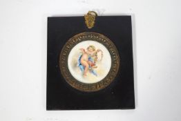 A Sevres style plaque, painted in enamels with a cherub holding a garland of flowers,