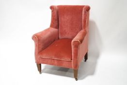An Edwardian wing armchair, upholstered in pink,