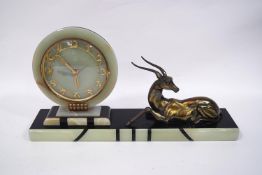An Art Deco marble and onyx mantel clock, modelled with a recumbent deer,