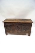 An 18th century oak coffer with hinged half lid and carved diamond decoration to the front panels,
