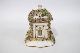 A 19th century Staffordshire pastille burner cottage, with separate base, encrusted with flowers,