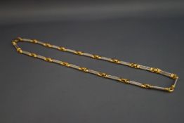 An 18 carat two colour gold necklace, signed Ramot, of double barley twist capped baton links,