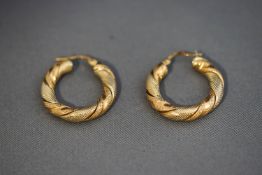 A pair of 9 carat two colour gold hoop earrings,
