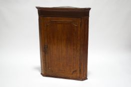 A George III oak cross banded corner cabinet
