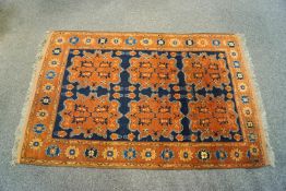 A Turkish rug with six medallions to central field, within a wide border and two narrow borders,