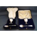 A silver egg cup and spoon, cased and monogrammed; with another silver egg cup and spoon,