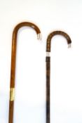 A pair of walking sticks with silver bands and tips,