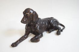 A bronze figure of a large recumbent dog,