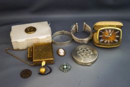 A silver bangle; another bangle; two compacts, a travel clock,