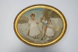 An oval silkwork picture of three children,