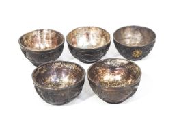 A set of four 19th century Chinese tixi lacquer wine cups, each decorated in relief with figures,