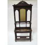 A Victorian carved oak hall stand with mirrored back, carved decoration and bobbin turned supports,