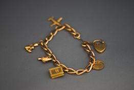 A 9 carat gold bracelet, of curb links, with charms attached, 21.