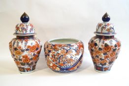 A pair of early 20th century Japanese Imari lidded vases, 35cm high and a similar Imari jardiniere,