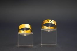 A wedding ring, stamped '18ct', 2.7 g gross; and a pierced ring, seemingly unmarked, 2.
