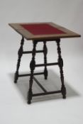 A Victorian oak swivel top card table with central maroon baize panel,