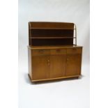 An Ercol style elm dresser with two tier plate rack over three drawers and cupboards,