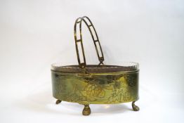An Arts & Crafts glass and brass dish, with swing handle, the brass engraved with artichokes,