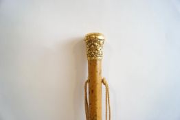 A gold topped walking cane, (un-marked,
