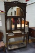 An early 20th century oak hall stand with demi-lune bevelled mirrored back and a single drawer,