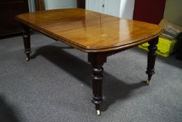 A Victoran mahogany wind out dining table with two additional narrow leaves,